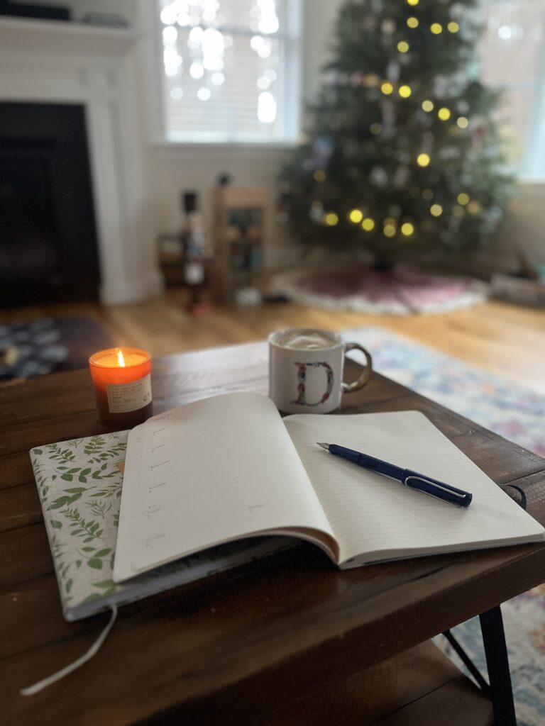planner on table with mug and candle
